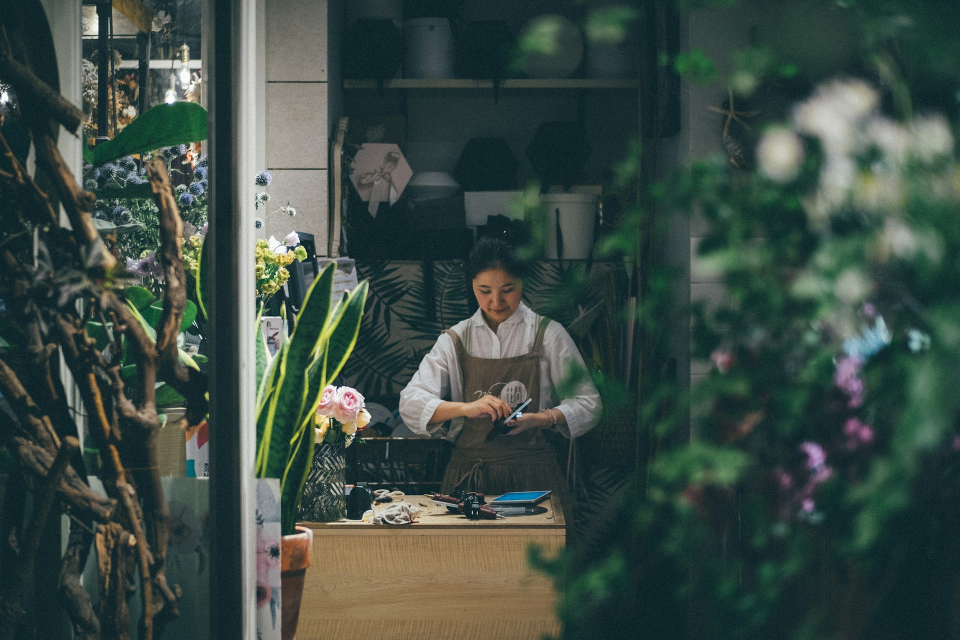 Fleuriste préparant un bouquet dans sa boutique, mutuelle et prévoyance collective CCN Fleuristes et Animaux Familiers (IDCC 1978)