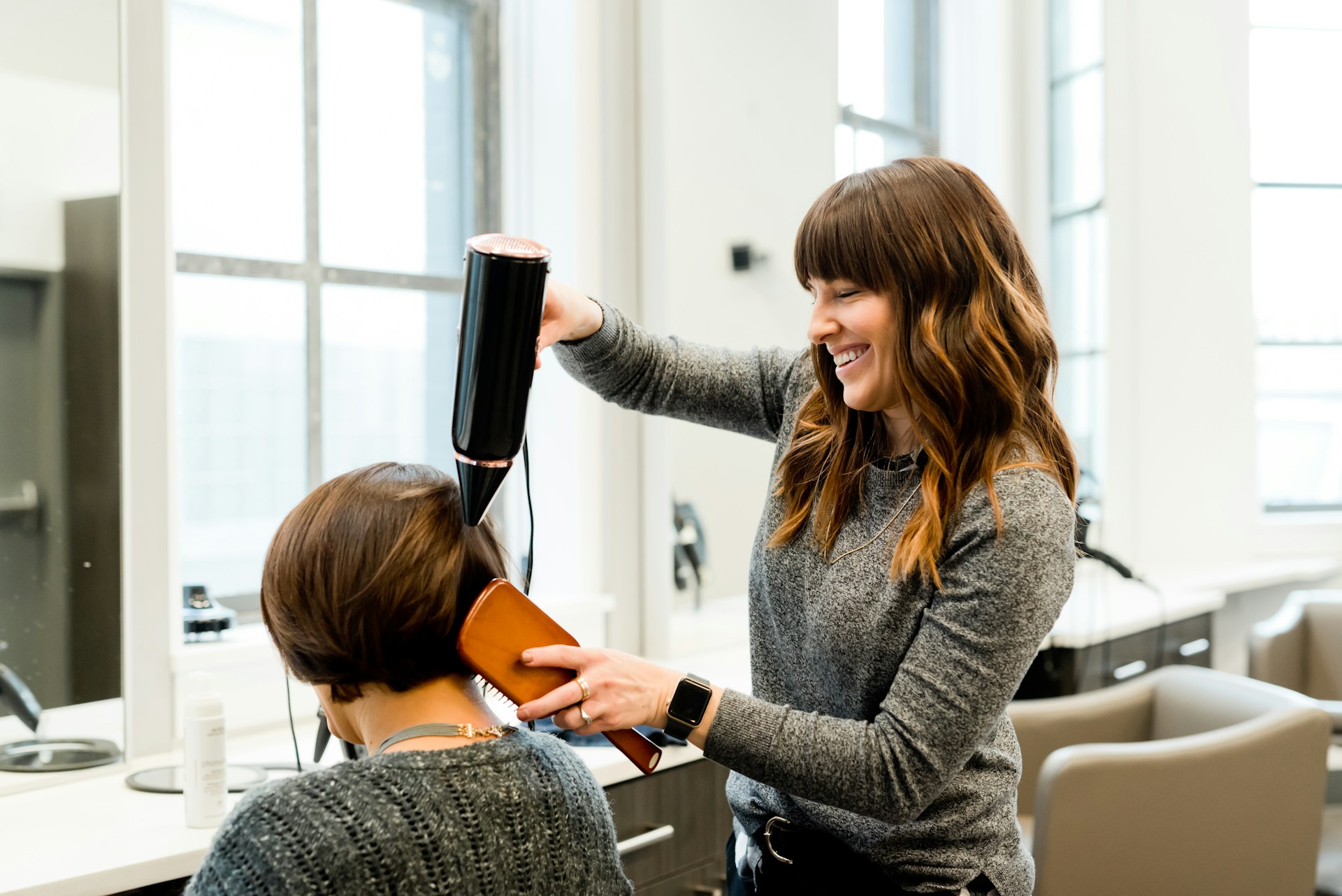 Mutuelle prévoyance coiffure : coiffeuse au travail dans un salon relevant de la convention collective IDCC 2596